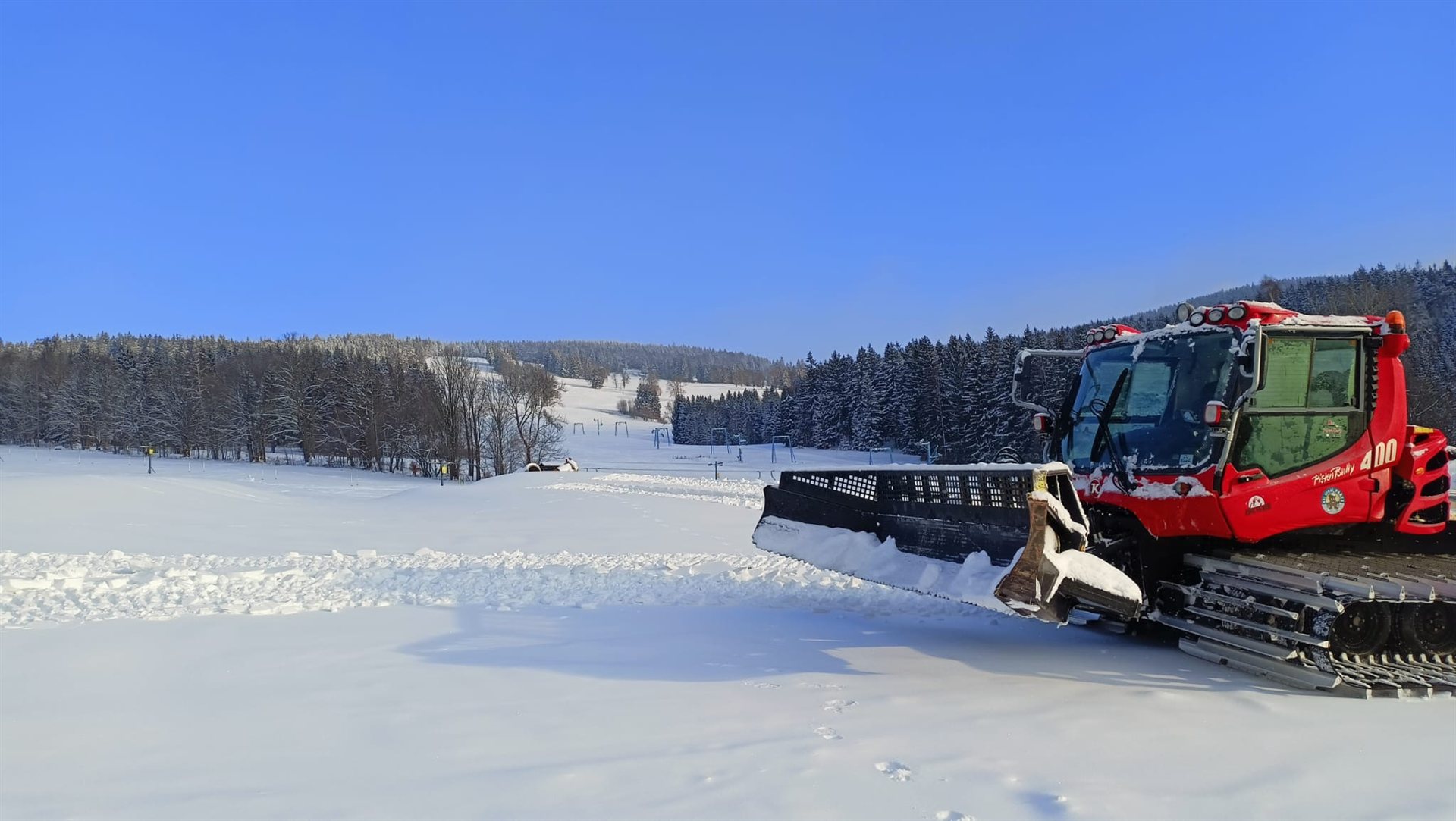 Rolba upravující sjezdovku Ski areálu Pařez za slunečného dne